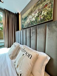 a bedroom with a bed with a painting on the wall at Erawan condo in Chiang Mai