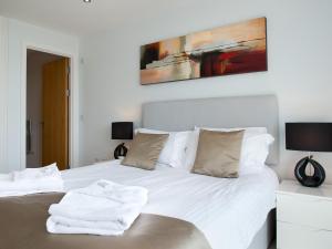 a bedroom with a bed with white sheets and pillows at Fistral View - 3 Cribbar in Newquay