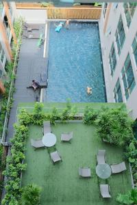 an overhead view of a swimming pool with tables and chairs at Erawan condo in Chiang Mai