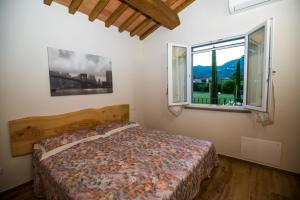 a bedroom with a bed and two windows at Tenuta il Giardino in Capannori