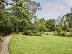 un patio de césped con un banco en un parque en Mill Cottage, Marsh Mills en Aveton Gifford