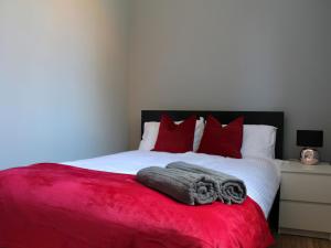 a bedroom with a bed with red pillows and a red blanket at Riverside Penthouse - Uk31551 in Matlock