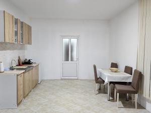 a kitchen with a table and a table and chairs at Apartman MAJ in Bijelo Polje