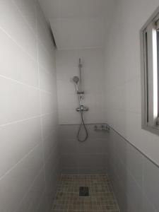 a white bathroom with a shower with a tile floor at La Cas'Aline in La Saline les Bains +9 photos