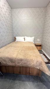 a bedroom with a large bed with two pillows at гостинично-ресторанный комплекс AMARI in Uralsk