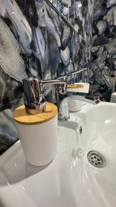 - un lavabo blanc avec un couvercle en bois dans l'établissement гостинично-ресторанный комплекс AMARI, à Uralsk