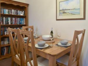 a dining room table with chairs and a book shelf at Sea Views no, 38 in Cayton