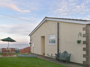 a house with a bench and a table and an umbrella at Sea Views no, 38 in Cayton