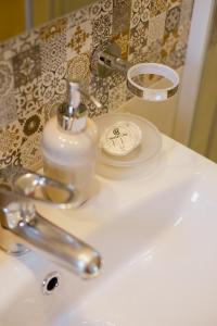 a bathroom sink with a soap bottle on it at Rooms in Yard in Kórinthos