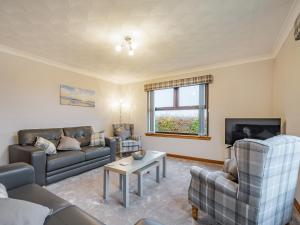 a living room with couches and a tv at Rowan Muir in Springside