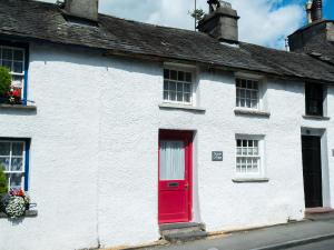 a white house with a red door on a street at Church Street in Ambleside