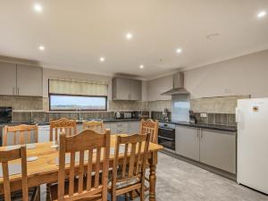 a large kitchen with a wooden table and chairs at Rowan Muir in Springside