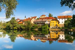 una ciudad que se refleja en el agua de un río en Vineyard Cottage Rataj 2 Wellness - Happy Rentals, en Novo Mesto