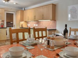 a kitchen with a table with plates and wine glasses at Anchorage Cottage in Lamlash