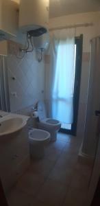 a bathroom with a toilet and a sink and a window at Stintino - Cala Lupo in Stintino
