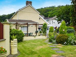 een huis met een tuin en een patio bij Ty Lewis Cottage in Llanelli