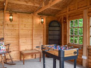 een tafeltennistafel in een kamer met houten wanden bij Ty Lewis Cottage in Llanelli