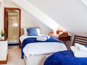 2 bedden in een zolderslaapkamer met een trap bij Ty Lewis Cottage in Llanelli