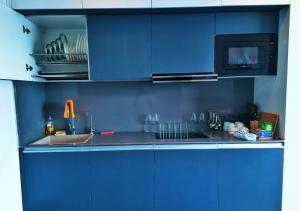 een blauwe keuken met een wastafel en een magnetron bij Luxury Studio Apartment , Delhi NCR in Noida