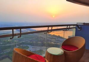 een balkon met stoelen en uitzicht op de zonsondergang bij Luxury Studio Apartment , Delhi NCR in Noida