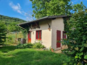 uma pequena casa com portas vermelhas num quintal em Gîte Lagney, 1 pièce, 2 personnes - FR-1-584-291 