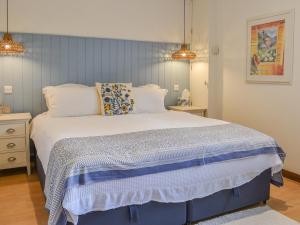 1 dormitorio con 1 cama grande y cabecero azul en The Parlour, en Hadlow Down