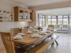 una cucina e una sala da pranzo con tavolo e sedie in legno di Llwyn Ysgaw a Cemaes Bay