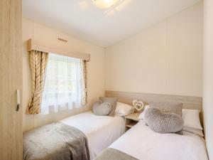 1 dormitorio con 2 camas y ventana en Ochil View Lodge en Dollar