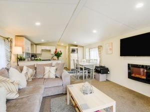 a living room with a couch and a tv at Ochil View Lodge in Dollar