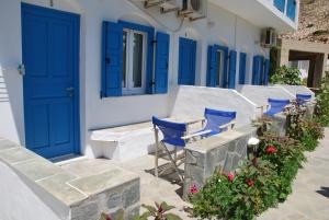 a row of blue doors and chairs on a building at Afroditi Hotel in Kamares