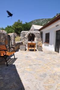 un banco sentado en un patio con un horno de piedra en Mountain Cottage Mons Baebius, en Starčevića Podi