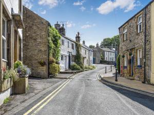 an empty street in a village with stone houses at Kings Cottage in Settle