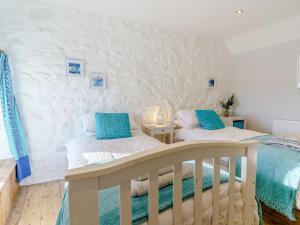 two beds in a bedroom with white walls at Bon Accorde in Goodwick