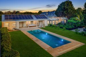 een huis met een zwembad en een huis met zonnepanelen bij Wembley House, Southern Highlands in Berrima