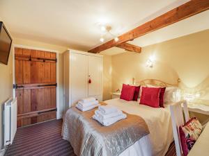 Un dormitorio con una cama con almohadas rojas. en Cowslip Cottage, en Swarland