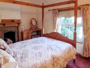 1 dormitorio con cama con dosel y chimenea en Mallard Cottage en Grosmont