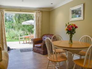 a living room with a table and a chair at Duck Cottage in Winterbourne Dauntsey