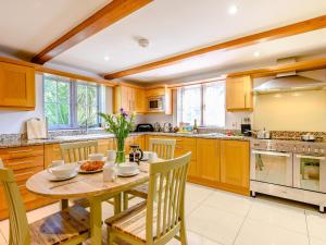 eine Küche mit Holzschränken, einem Holztisch und Stühlen in der Unterkunft Hambury House in West Lulworth
