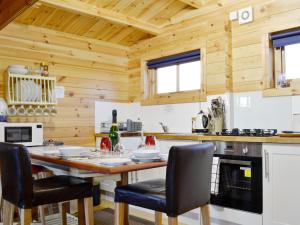 a kitchen with a large wooden table and chairs at The Cwtch - Uk30049 in Llanwnda