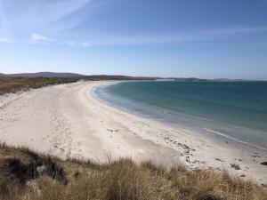 a sandy beach with the ocean in the background at Taigh Violet Rose in Gramisdale