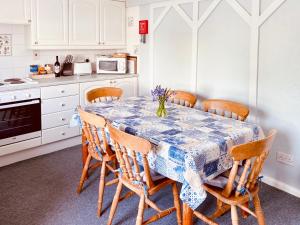 a kitchen with a table with a blue and white table cloth at The Haven in Crantock