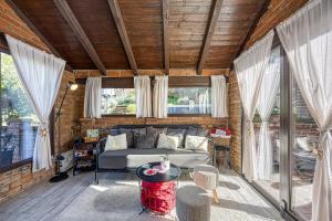 a living room with a couch and a table at Romantic Haven with Hot Tub - Happy Rentals in Beretinec