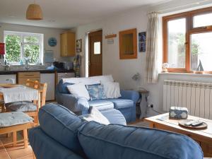 a living room with a blue couch and a kitchen at Sea View - Uk30589 in Polperro