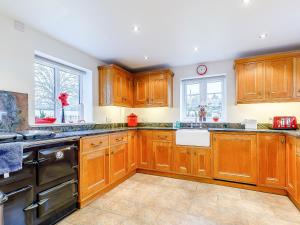 a kitchen with wooden cabinets and black appliances at The Old Vicarage in Stowe