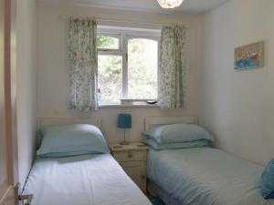 two beds in a room with a window at Sea View - Uk30589 in Polperro
