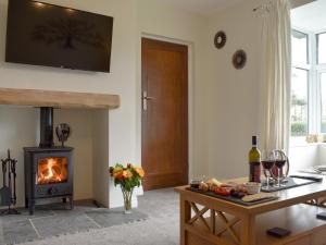 sala de estar con chimenea y fogones en Manor Park Cottage, en Knitsley