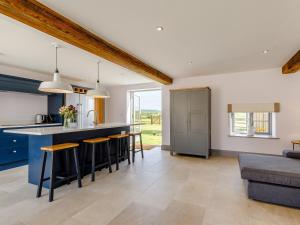 a kitchen and living room with blue cabinets and a counter at The Hayloft - Uk34565 in Whitchurch