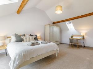 um quarto com uma grande cama branca e uma secretária em The Hayloft - Uk34565 em Whitchurch