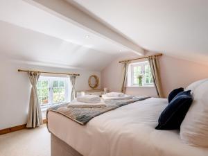a bedroom with a large bed in a attic at Box Tree Cottage in Blakeney