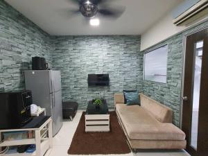 ein Wohnzimmer mit Sofa und Ziegelwand in der Unterkunft Duplex Condo Sec 14 Shah Alam in Shah Alam